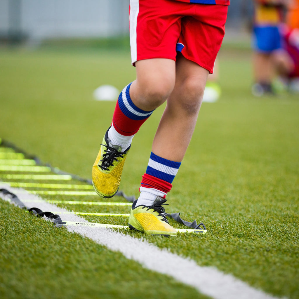 a man using the agility ladder on the ground