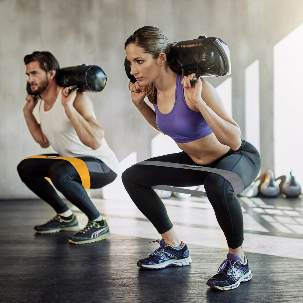 a boy and a girl using the Resistance Exercise Booty Bands in the gym